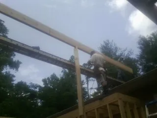 Carpenter setting a ridge beam over a new addition frame — Ice Dam Removal by Roofing Brothers in Wurtsboro