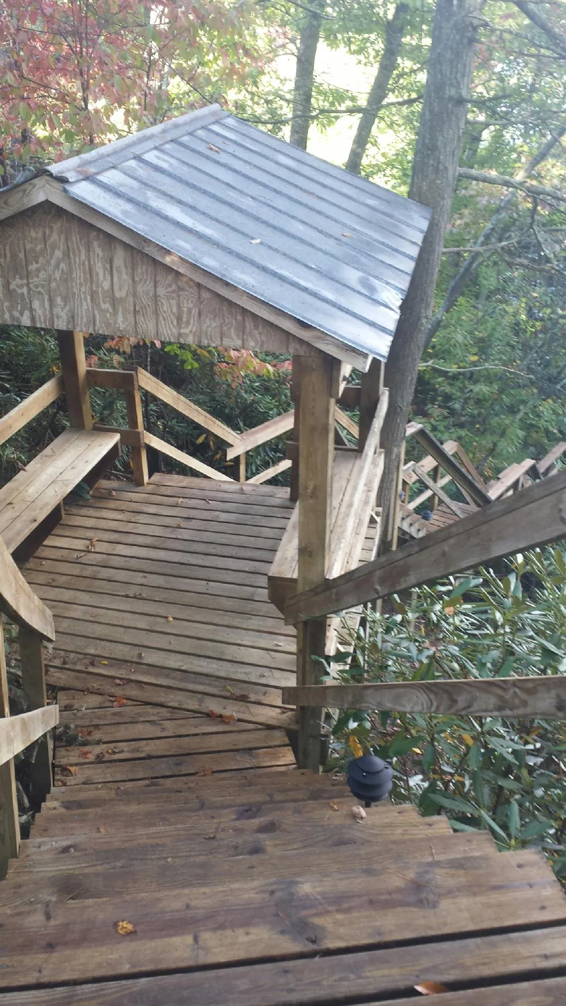 Metal roofed shelter over wooden steps on a wooded walkway — Skylight Repair & Installation work by our crew in Wurtsboro